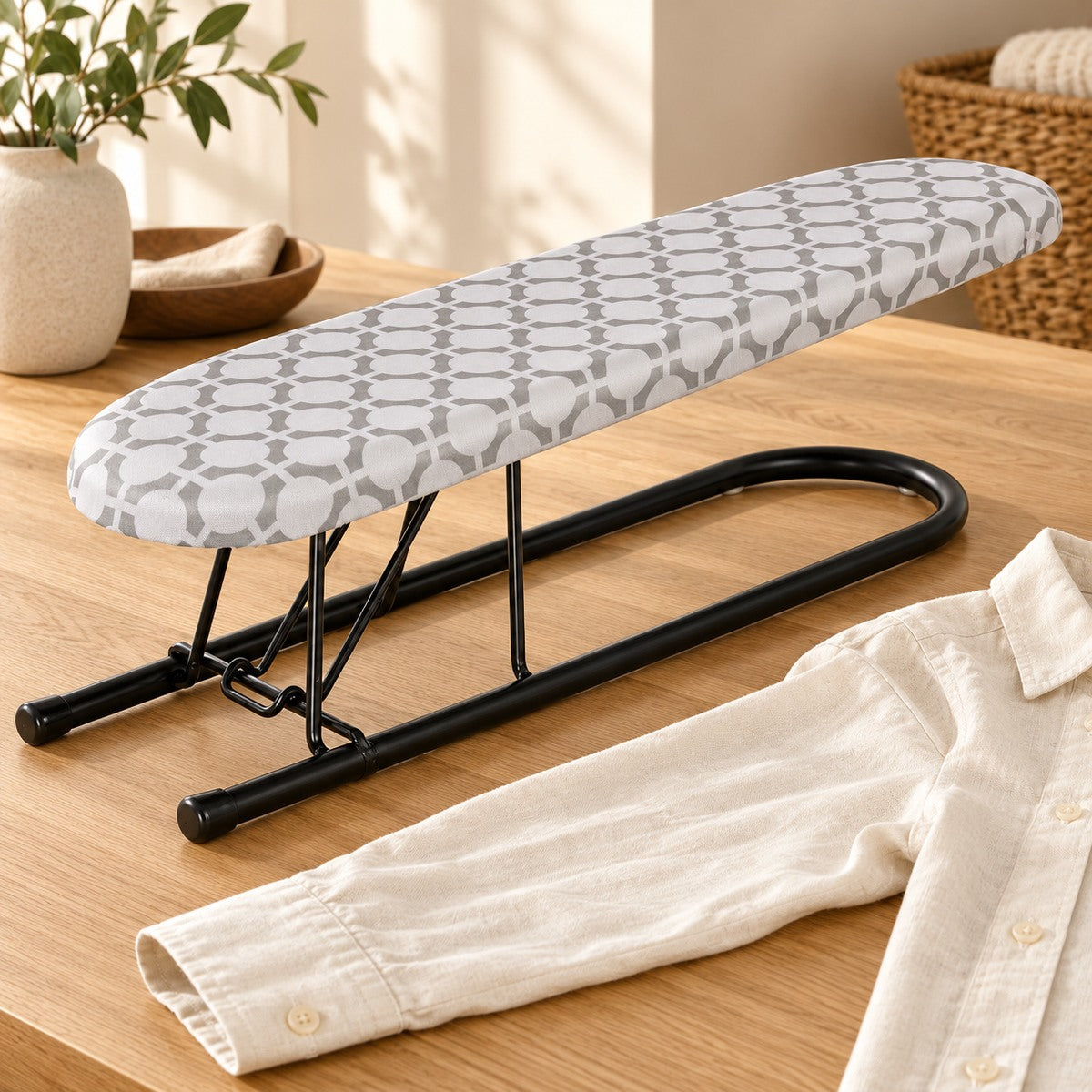 Petite planche à manches sur une table en bois à côté d'une chemise en lin.